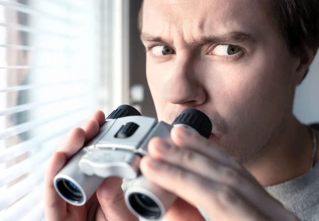 Verdächtiger Mann mit Fernglas